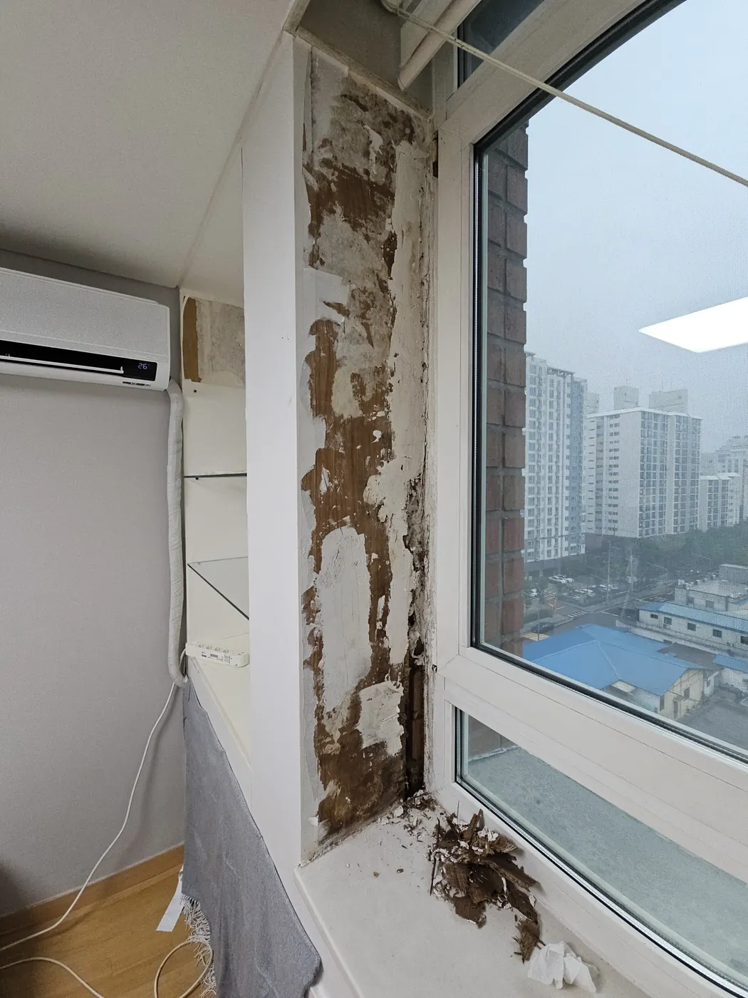 창문 주변 벽면 마감재가 갈라지고 들뜬 손상 상태